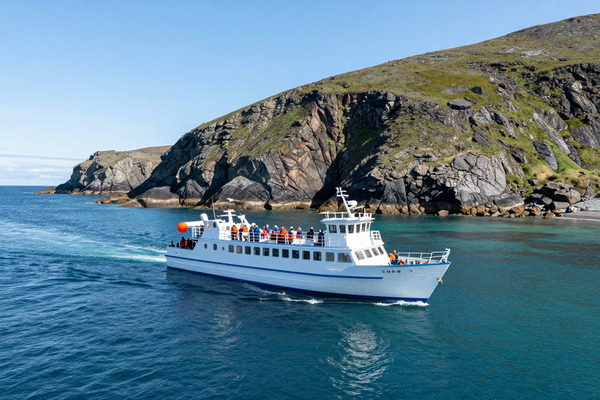 Tourist boat sea excursion in Pacific ocean near Kamchatka, rocky coastline, clear water