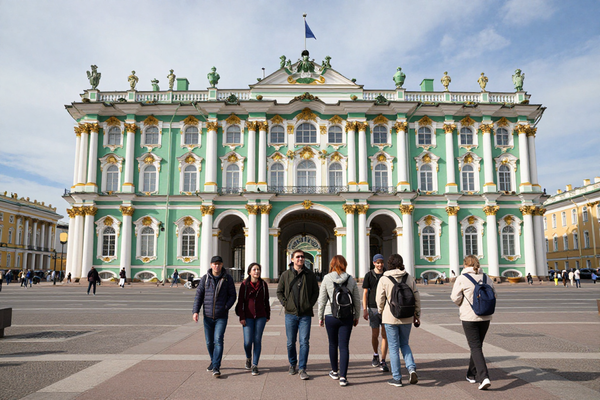 Group of tourists on excursion in St Petersburg, Hermitage museum exterior, European tourists